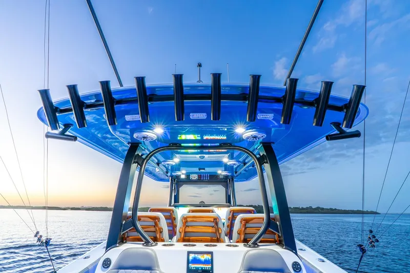 Slide: The Image of 2025 Freeman 43 boat with illuminated canopy and fishing rod holders at sunset. - 27