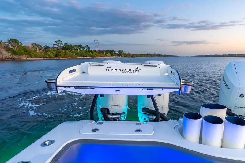 Slide: The Image of 2025 Freeman 43 boat with powerful engines cruising on a serene waterway at sunset. - 42