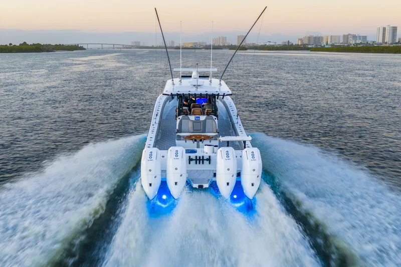 Slide: The Image of 2025 Freeman 43 boat cruising on water at sunset with fishing rods and passengers. - 5