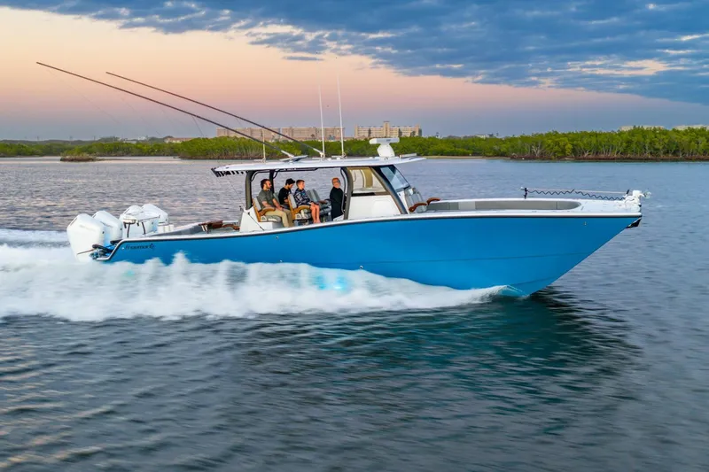 Slide: The Image of 2025 Freeman 43 boat cruising on water at sunset with passengers onboard. - 8