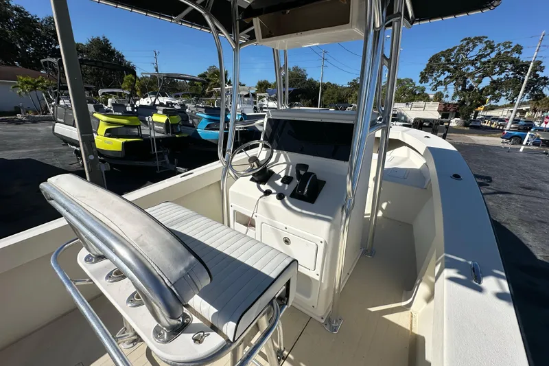 Slide: The Image of 1977 SeaCraft 23 CC boat interior with steering console and seating, parked outdoors. - 11
