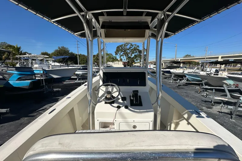 Slide: The Image of 1977 SeaCraft 23 CC boat interior with steering wheel and console, parked in a marina. - 12