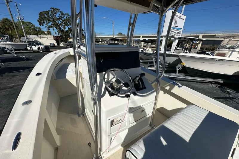Slide: The Image of 1977 SeaCraft 23 CC boat interior with steering console and seating, docked outdoors. - 13