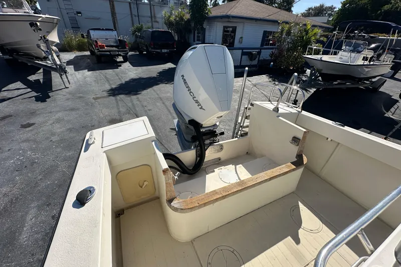 Slide: The Image of 1977 SeaCraft 23 CC boat with Mercury outboard engine in a parking lot. - 15