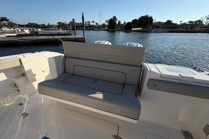 Slide: The Image of 2023 Pursuit S 328 Sport boat interior with cushioned seating by the water. - 14