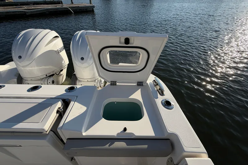 Slide: The Image of 2023 Pursuit S 328 Sport boat with open hatch and twin engines on water. - 15