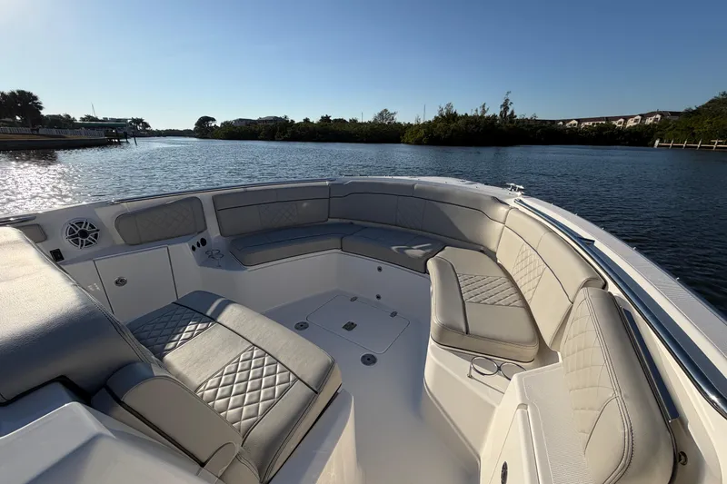 Slide: The Image of Luxurious seating area on 2023 Pursuit S 328 Sport boat, overlooking serene water. - 19