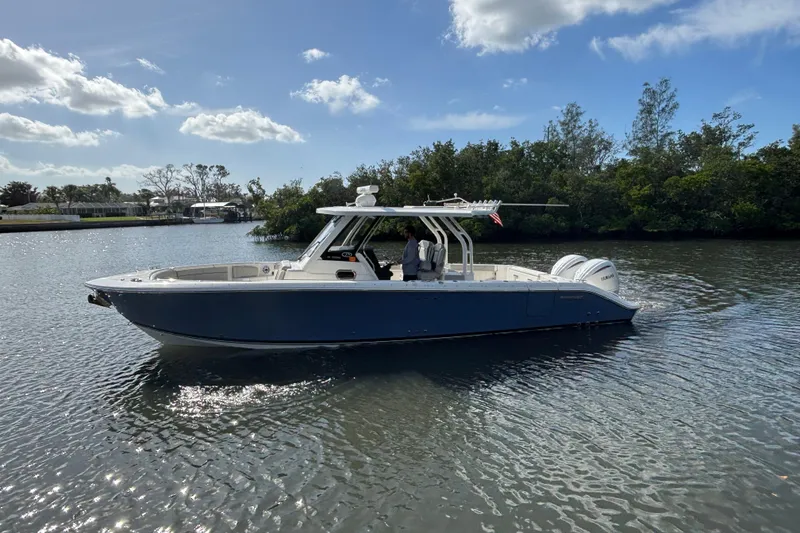 Slide: The Image of 2023 Pursuit S 328 Sport boat on calm water under a clear sky. - 4