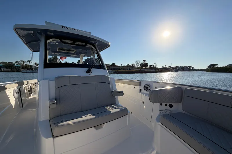 Slide: The Image of 2023 Pursuit S 328 Sport boat interior with seating, on a sunny day by the water. - 9