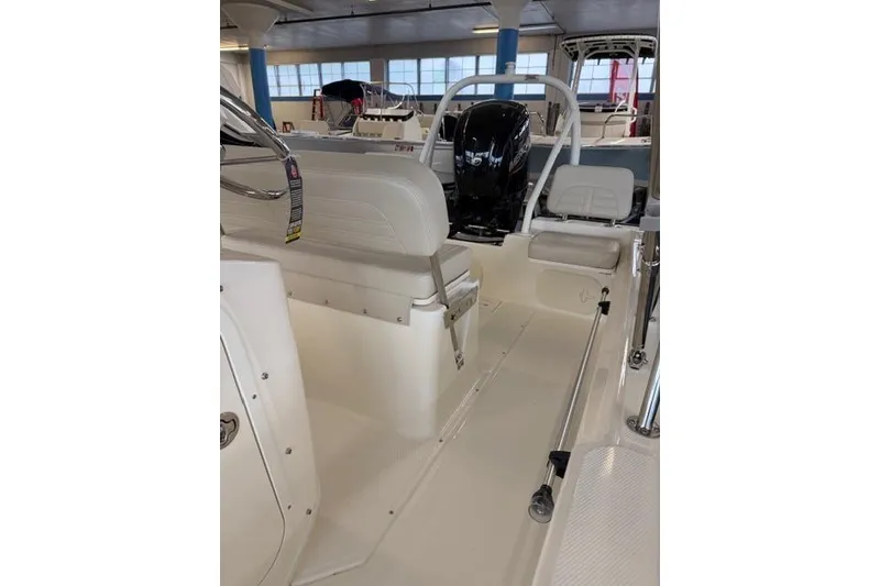 Slide: The Image of 2026 Boston Whaler 170 Montauk interior with seating and motor in showroom. - 10
