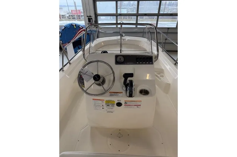 Slide: The Image of 2026 Boston Whaler 170 Montauk boat console with steering wheel and controls. - 10