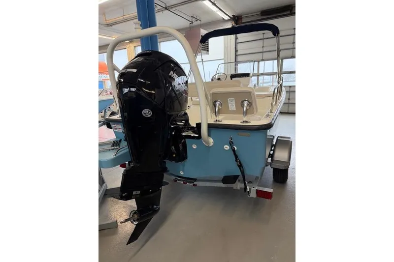 Slide: The Image of 2026 Boston Whaler 170 Montauk boat with outboard motor in showroom. - 2