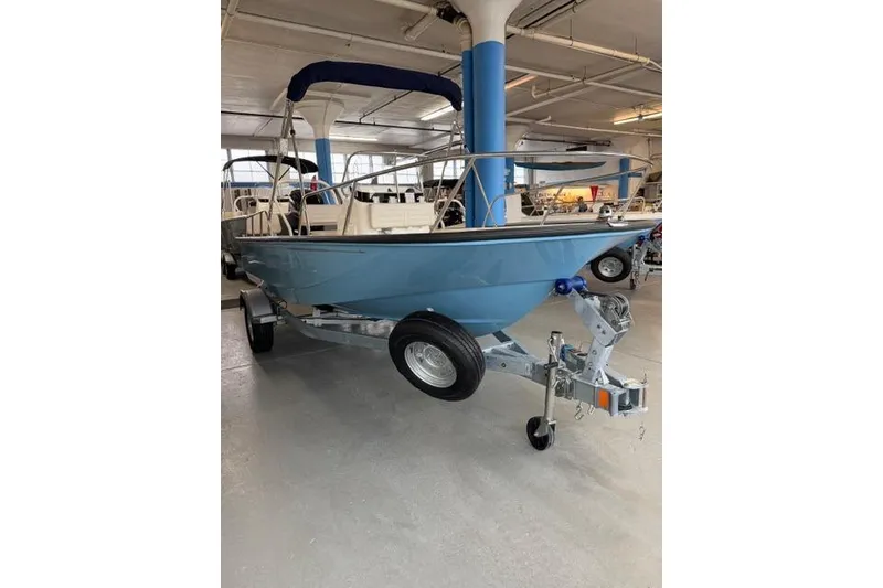 Slide: The Image of 2026 Boston Whaler 170 Montauk boat on trailer in indoor showroom. - 3