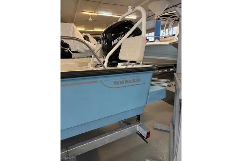 Slide: The Image of 2026 Boston Whaler 170 Montauk boat in showroom, featuring a Mercury engine. - 4
