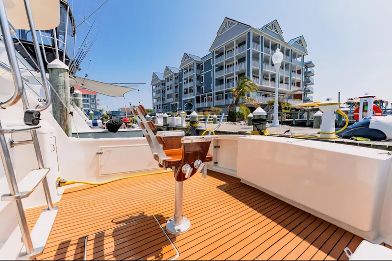 Slide: The Image of 1988 Ocean Yachts 48 Super Sport docked, featuring spacious deck and modern marina backdrop. - 32