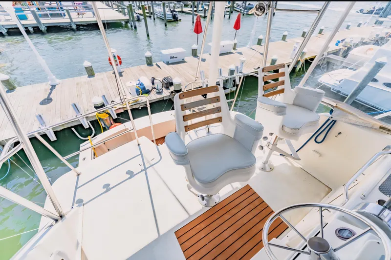 Slide: The Image of 1988 Ocean Yachts 48 Super Sport cockpit with helm chairs and marina view. - 17