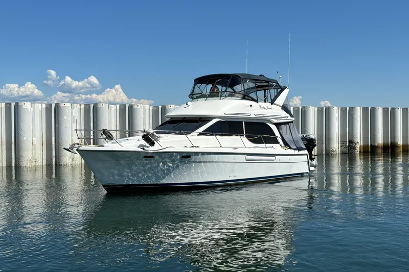 Slide: The Image of 2000 Bayliner 3788 Command Bridge Motoryacht on calm water, clear sky background. - 1