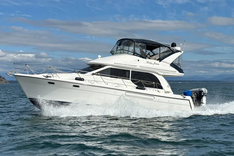 The Image of 2000 Bayliner 3788 Command Bridge Motoryacht cruising on open water under a clear sky. - 0