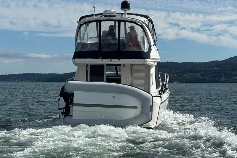 Slide: The Image of 2000 Bayliner 3788 Command Bridge Motoryacht cruising on a scenic lake. - 3