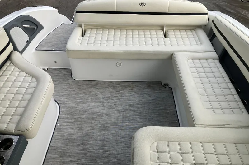 Slide: The Image of 2021 Cobalt R7 Surf boat interior with white cushioned seating and gray flooring. - 30