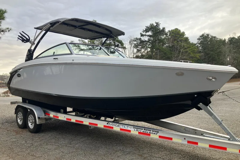Slide: The Image of 2021 Cobalt R7 Surf boat on trailer, parked outdoors with trees in background. - 4