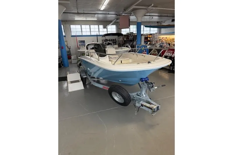 Slide: The Image of 2026 Boston Whaler 160 Super Sport boat displayed indoors on a trailer. - 3