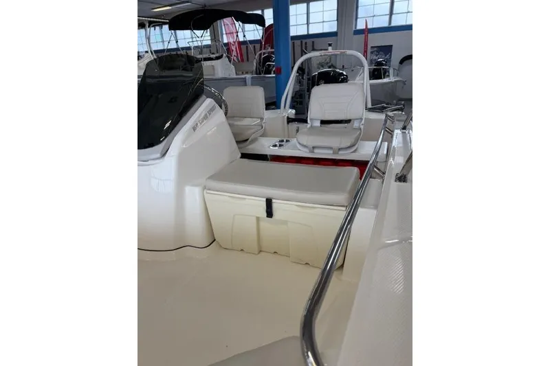 Slide: The Image of 2026 Boston Whaler 160 Super Sport interior with seating and storage, displayed indoors. - 9