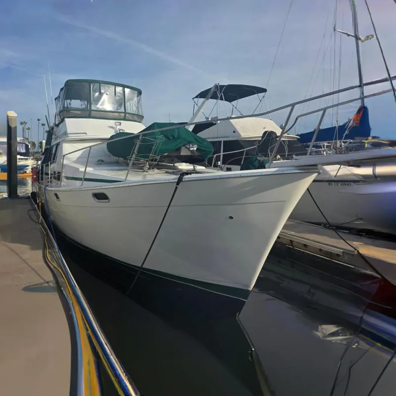 The Image of 1989 Bayliner 3888 Motoryacht docked at a marina under clear skies. - 0