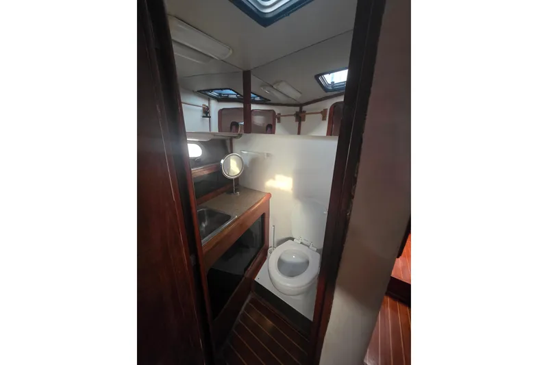 Slide: The Image of 1989 Bayliner 3888 Motoryacht bathroom with sink, toilet, and wooden accents. - 23