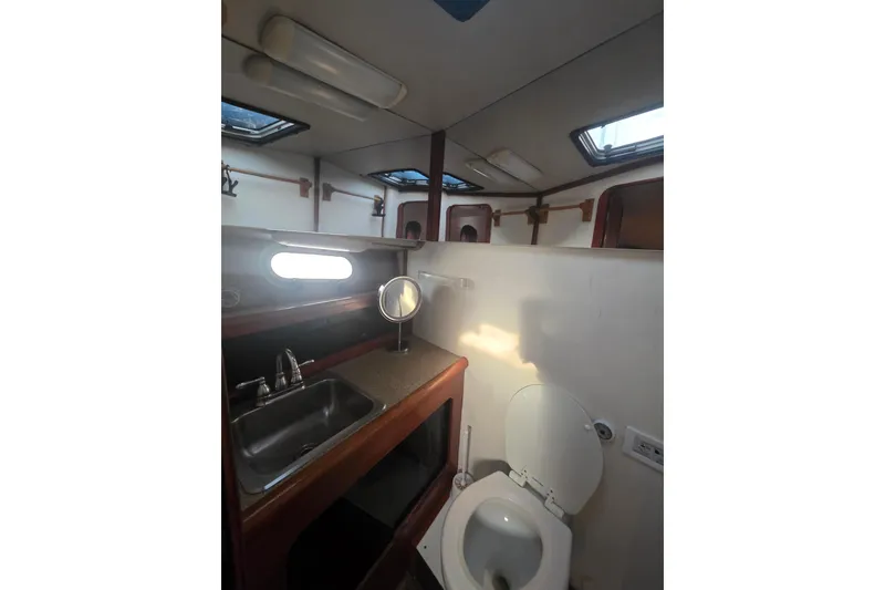 Slide: The Image of 1989 Bayliner 3888 Motoryacht bathroom with sink, toilet, and mirror. - 24