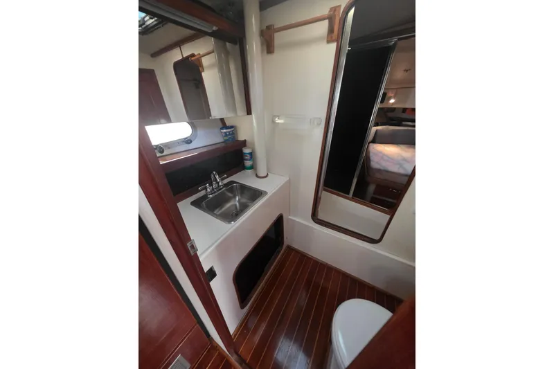 Slide: The Image of 1989 Bayliner 3888 Motoryacht bathroom with sink, mirror, and wooden flooring. - 27