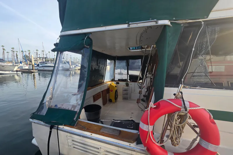 Slide: The Image of 1989 Bayliner 3888 Motoryacht docked, featuring green canopy and life preserver. - 36