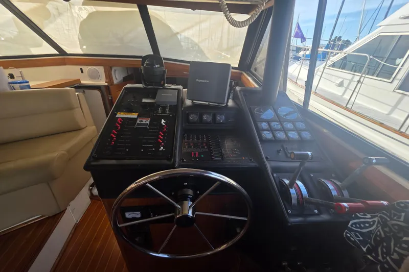 Slide: The Image of 1989 Bayliner 3888 Motoryacht helm with steering wheel, controls, and navigation equipment. - 6
