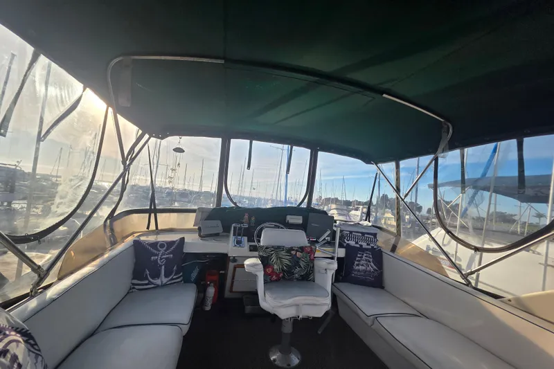 Slide: The Image of 1989 Bayliner 3888 Motoryacht interior with seating and helm, marina view. - 9