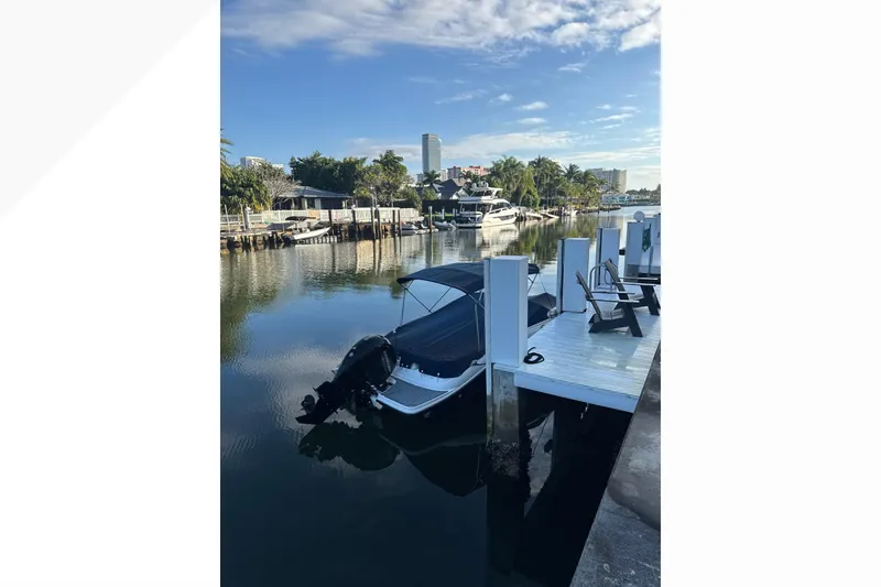 Slide: The Image of 2022 Sea Ray 19 SPX OB docked by a scenic waterfront with clear skies. - 13