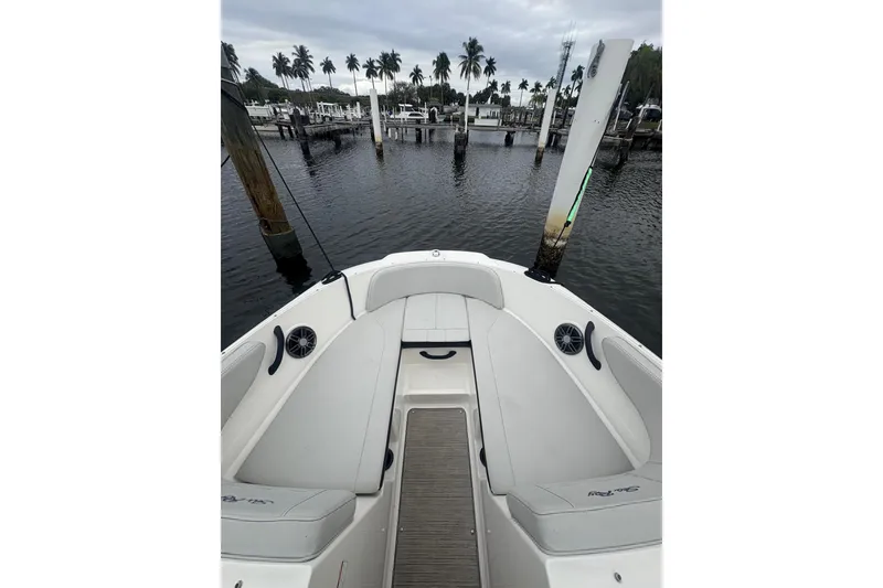 Slide: The Image of 2022 Sea Ray 19 SPX OB boat interior with seating, docked near palm trees. - 14
