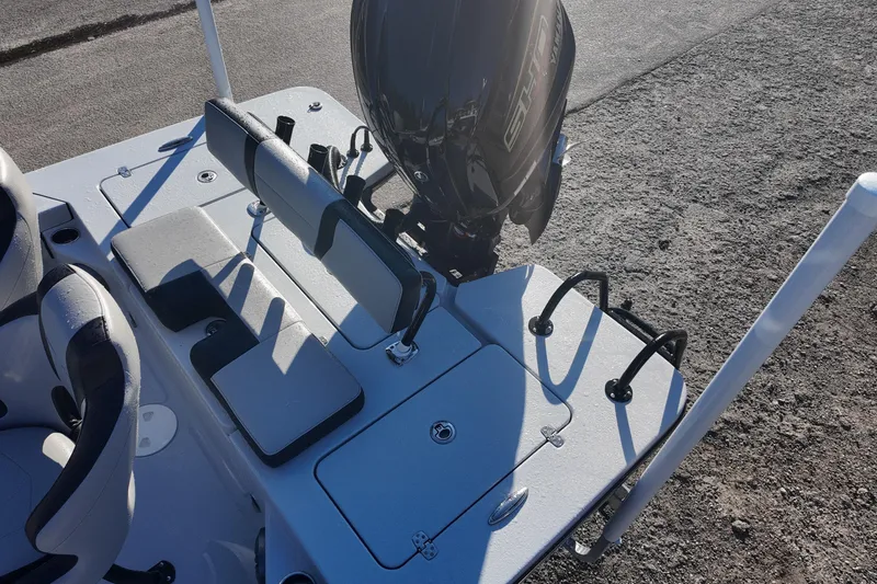 Slide: The Image of 2026 Blazer 675 Ultimate Bay boat interior with seating and motor, on a sunny day. - 14