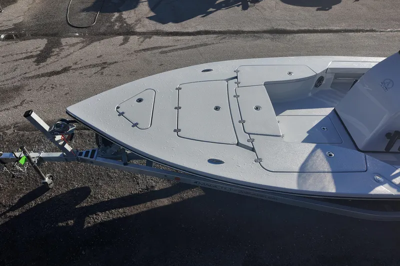 Slide: The Image of 2026 Blazer 675 Ultimate Bay boat on trailer, top view, parked on asphalt. - 16