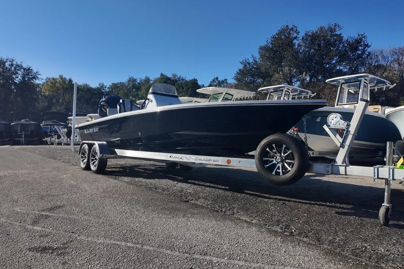Slide: The Image of 2026 Blazer 675 Ultimate Bay boat on trailer in sunny outdoor setting. - 2