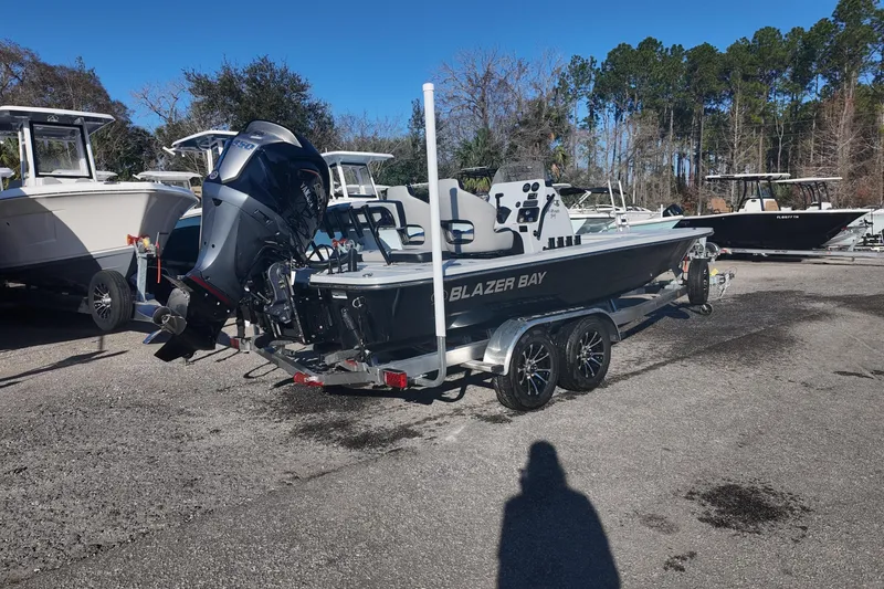 Slide: The Image of 2026 Blazer 675 Ultimate Bay boat on trailer, parked outdoors with other boats. - 3