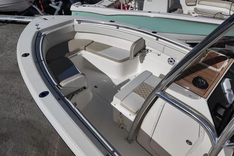 Slide: The Image of 2025 Bulls Bay 255 CC boat interior with seating and console, docked outdoors. - 10