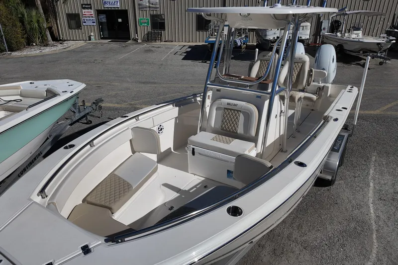 Slide: The Image of 2025 Bulls Bay 255 CC boat with seating, parked at a dealership. - 11
