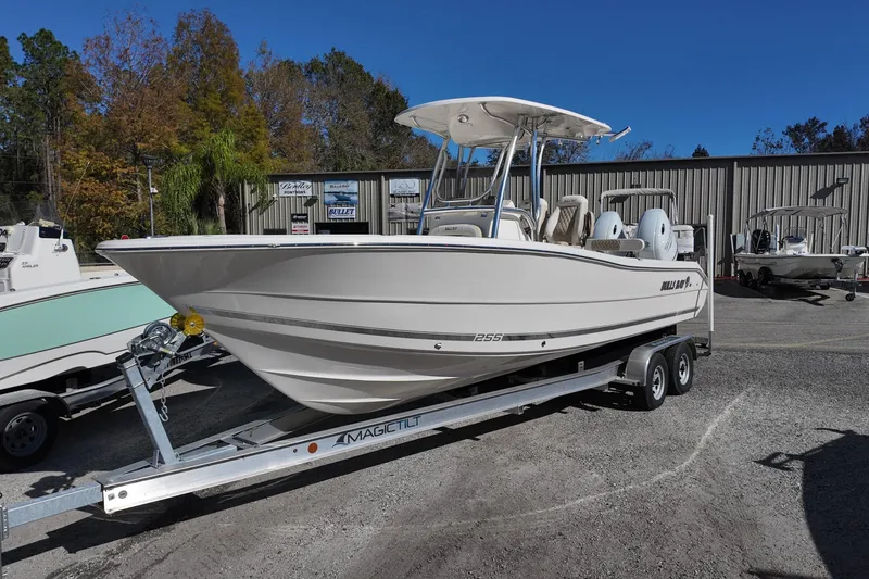Slide: The Image of 2025 Bulls Bay 255 CC boat on trailer, parked outdoors near a building. - 4