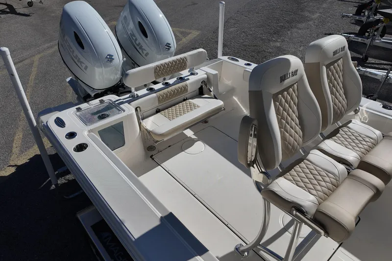 Slide: The Image of 2025 Bulls Bay 255 CC boat interior with dual engines and cushioned seating. - 7