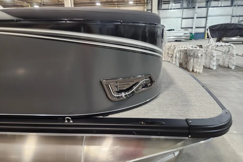 Slide: The Image of 2026 Tahoe Pontoon 23 LTZ Quad Lounge speaker with blue LED lighting on gray flooring. - 21