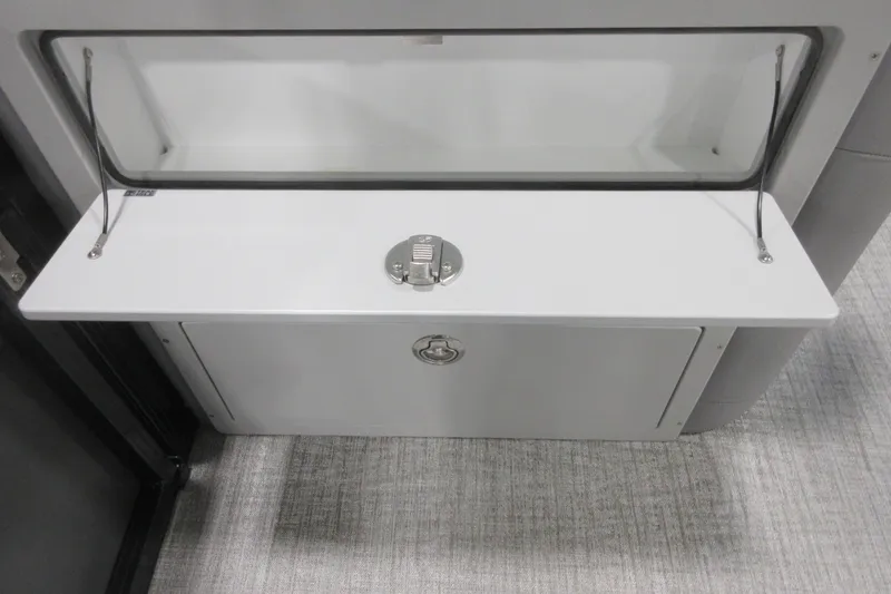 Slide: The Image of 2026 Tahoe Pontoon 23 LTZ Quad Lounge storage compartment with secure latch and sleek design. - 93