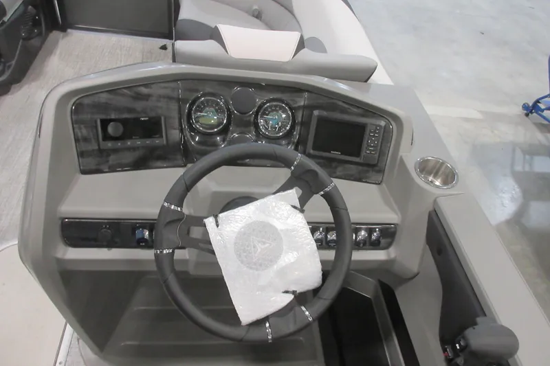Slide: The Image of Steering console of 2026 Tahoe Pontoon 23 LTZ Quad Lounge with modern controls and gauges. - 99