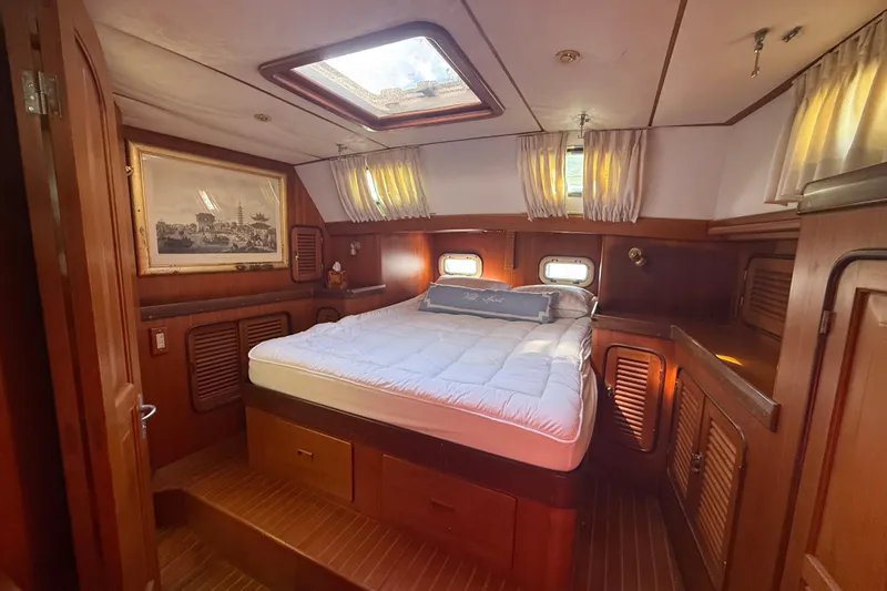 Slide: The Image of Luxurious 1999 Passport 456 yacht cabin with cozy bed and elegant wood paneling. - 16