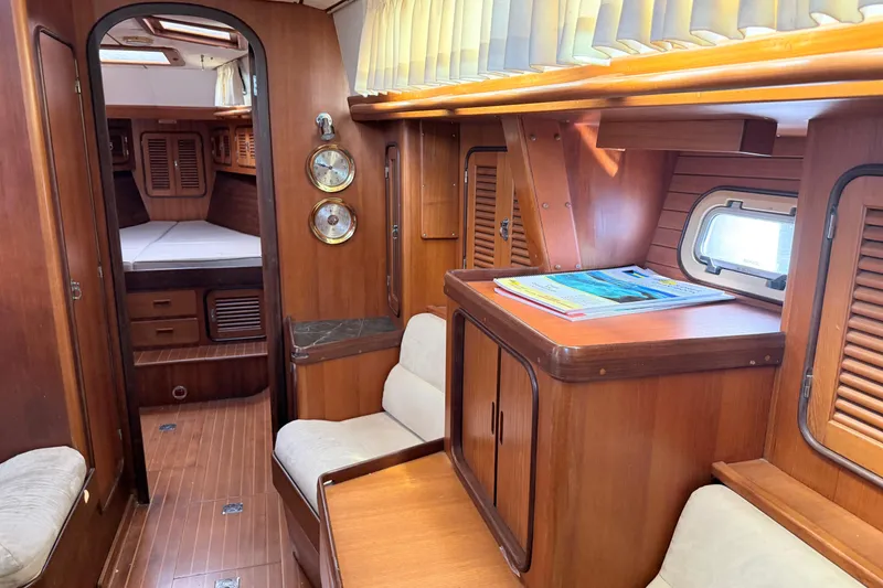Slide: The Image of Interior of a 1999 Passport 456 yacht with wooden furnishings and cozy seating. - 21