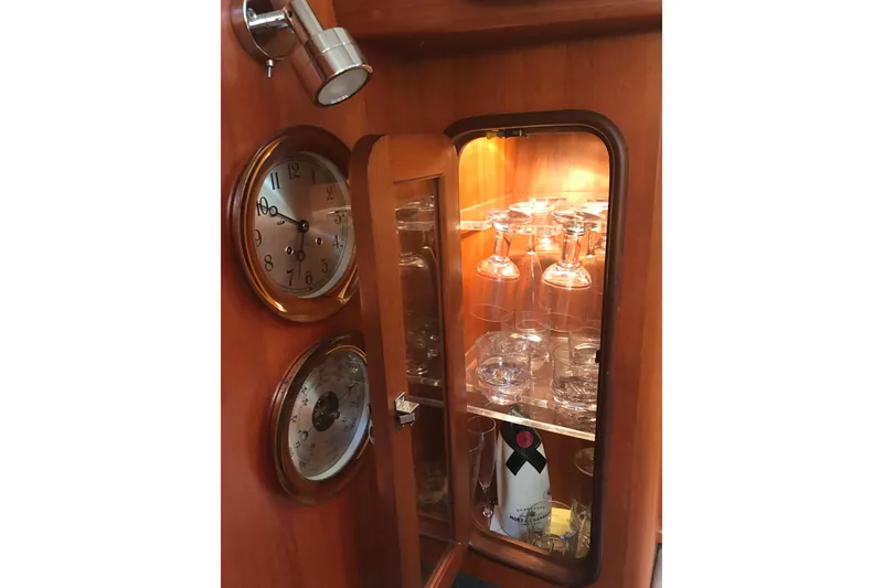 Slide: The Image of Wooden cabinet with glassware, clock, and barometer on a Passport 456, 1999 model. - 22
